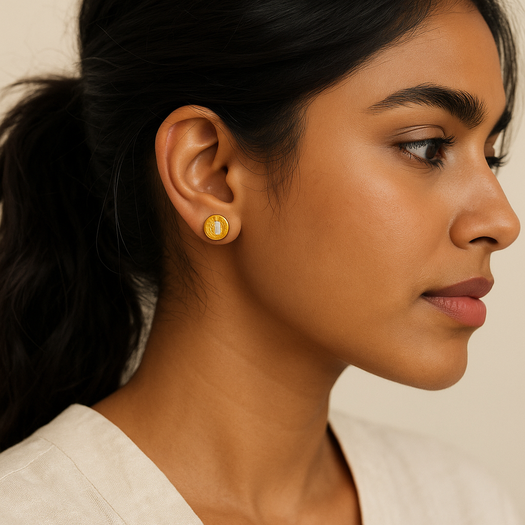Close-up of a woman wearing gold earrings with a neutral background