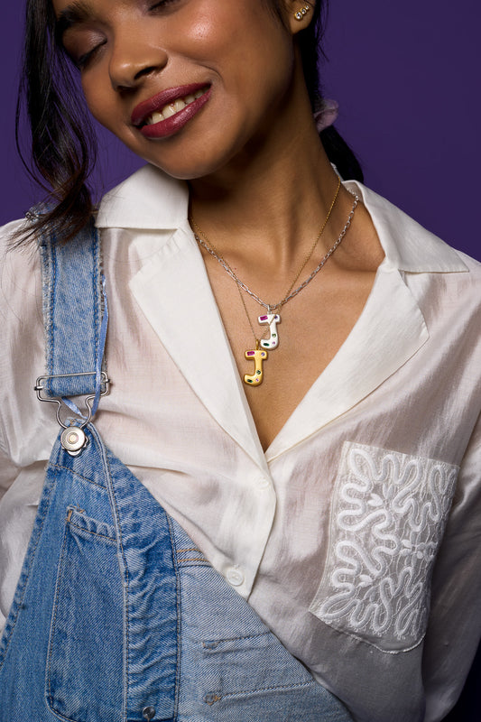 Woman wearing a white blouse and blue denim overalls with a purple background