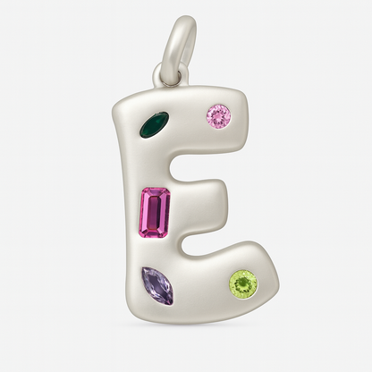Silver pendant shaped like the letter 'E' with colorful gemstones on a white background