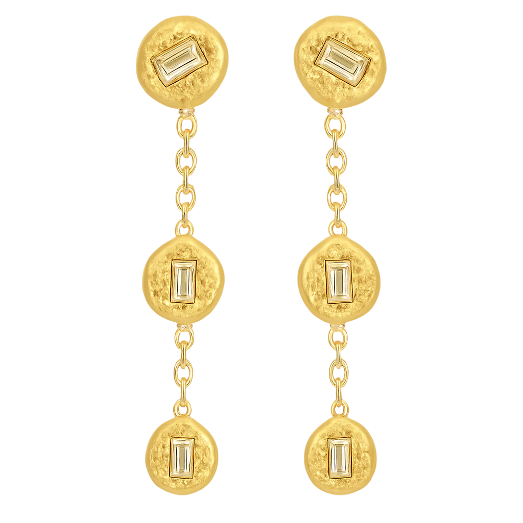 Gold earrings with circular designs and baguette gemstones on a white background