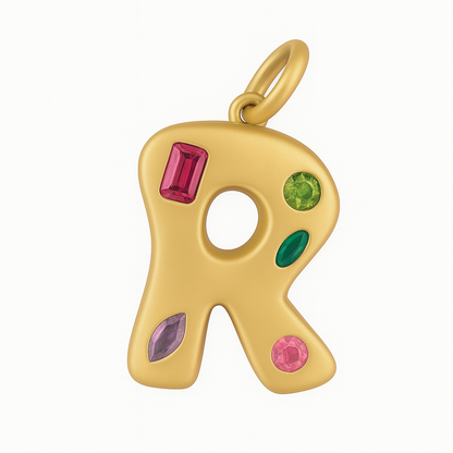Gold pendant shaped like the letter 'R' with colorful gemstones on a white background