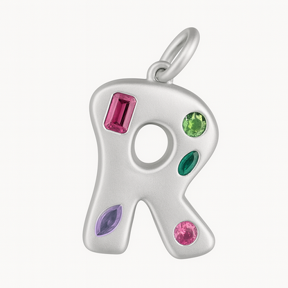 Silver R shaped pendant with colorful gemstones on a white background