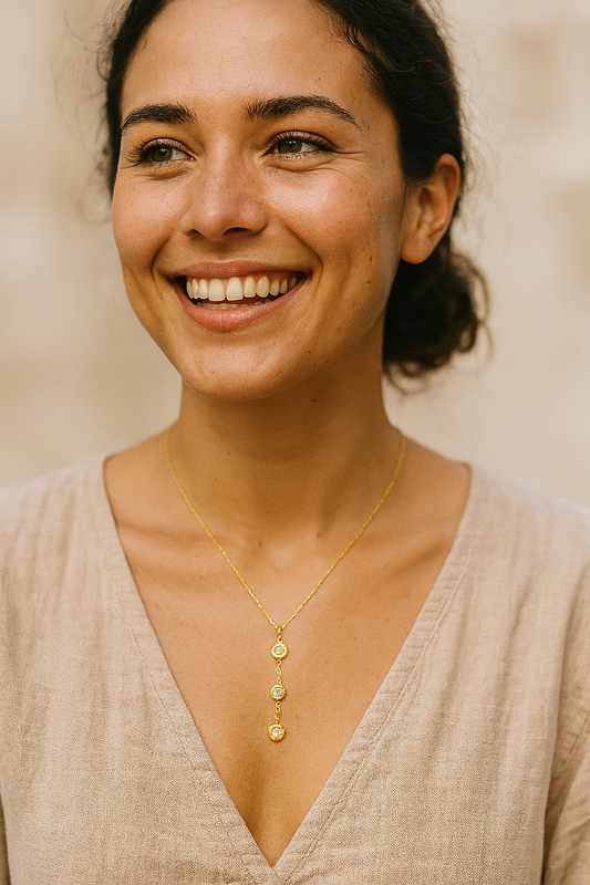 Woman wearing a gold necklace with a neutral background