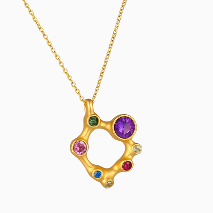 Gold necklace with a circular pendant featuring multicolored gemstones on a white background
