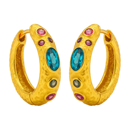 Gold hoop earrings with blue and pink gemstones on a white background